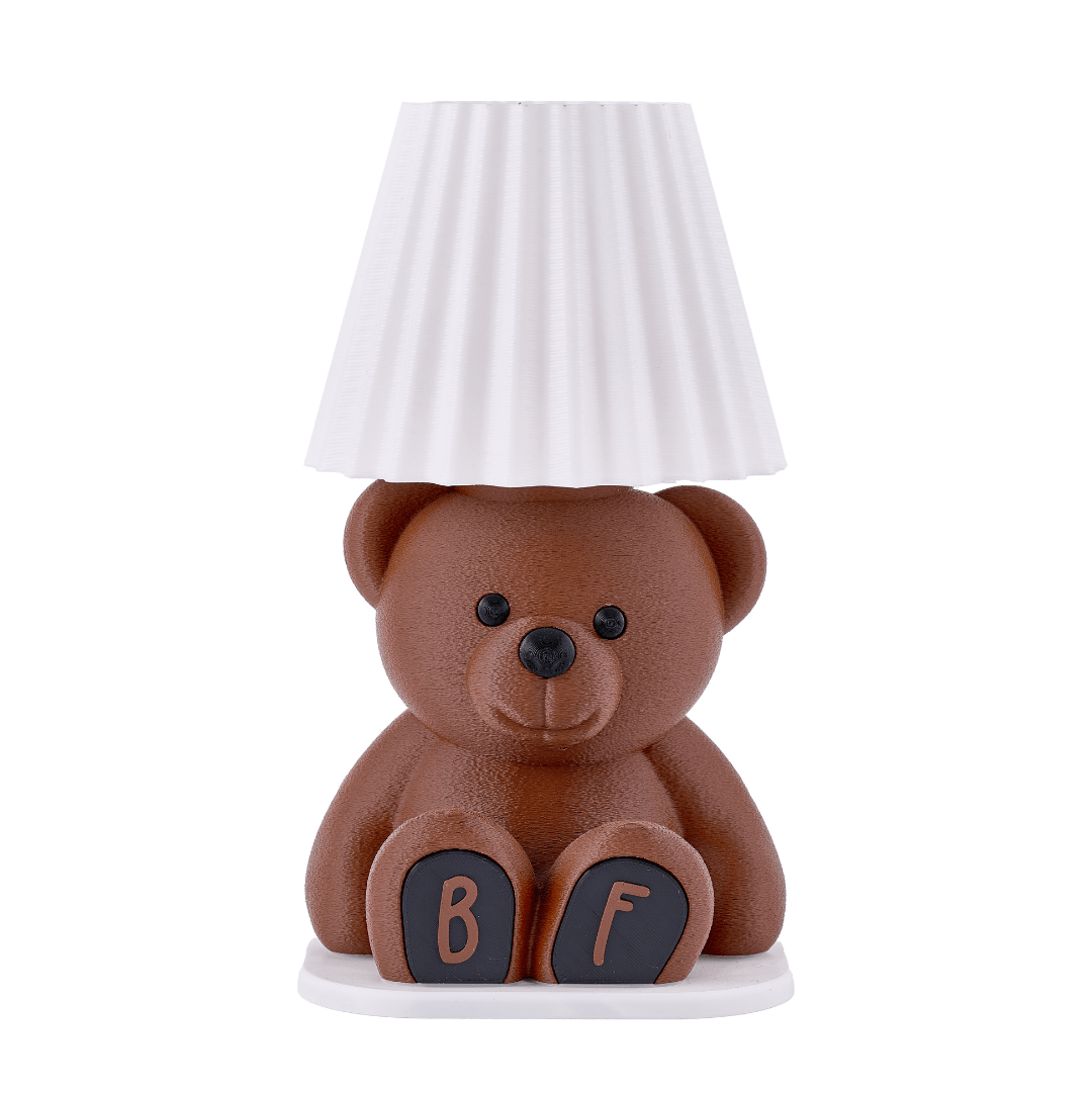 Teddy bear-shaped lamp with a white lampshade on a white background
