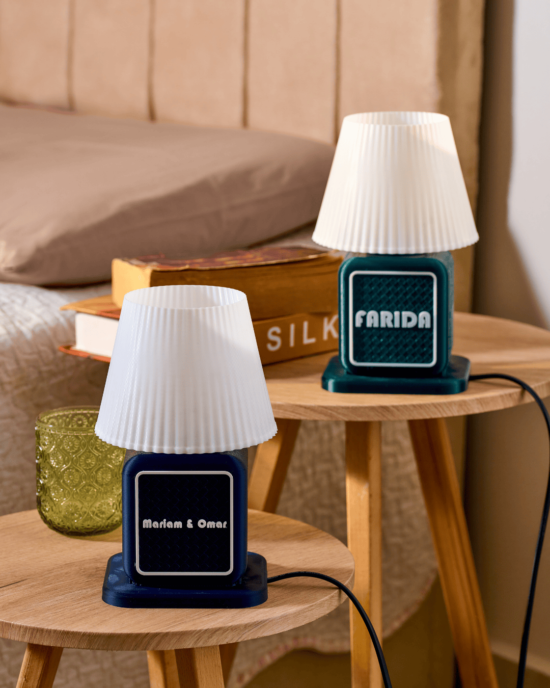 Two small retro radio lamps with white lampshades on wooden tables, one labeled 'Farida' and the other 'Marlam & Omar'.